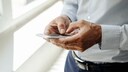 Ein Mann mit Smartphone in der Hand beim Tippen