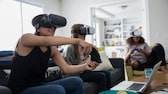 Drei Frauen spielen VR mit Controllern