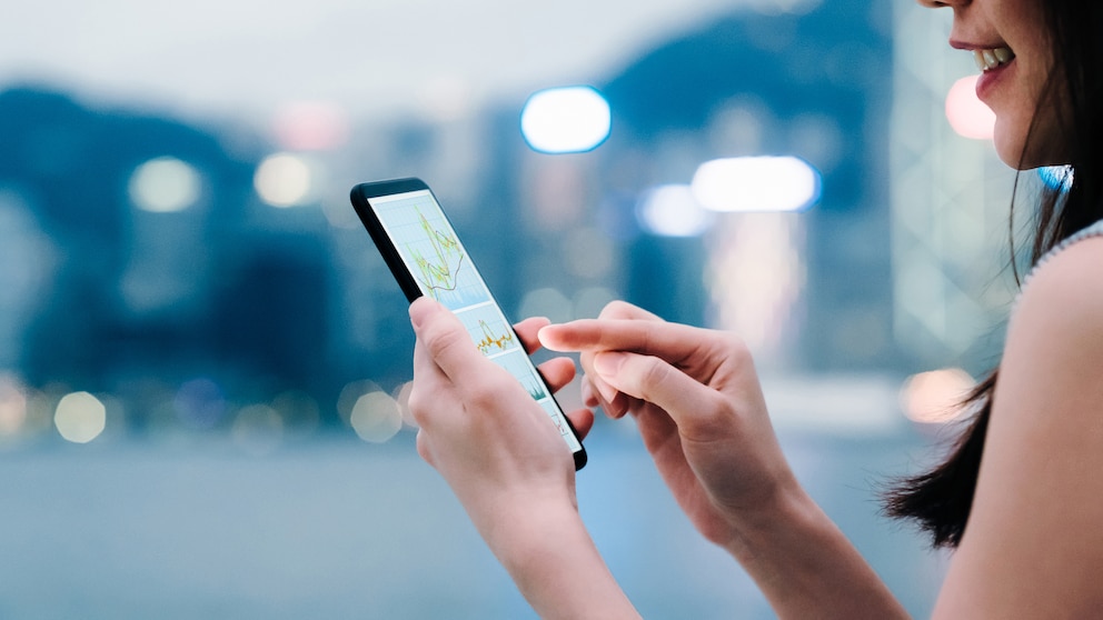 Frau mit einem Smartphone in der Hand, Hintergrund unscharf