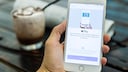 Hand hält Handy auf dem Apple Pay zu sehen ist