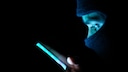 Maskierter Hacker mit Smartphone