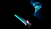 Maskierter Hacker mit Smartphone