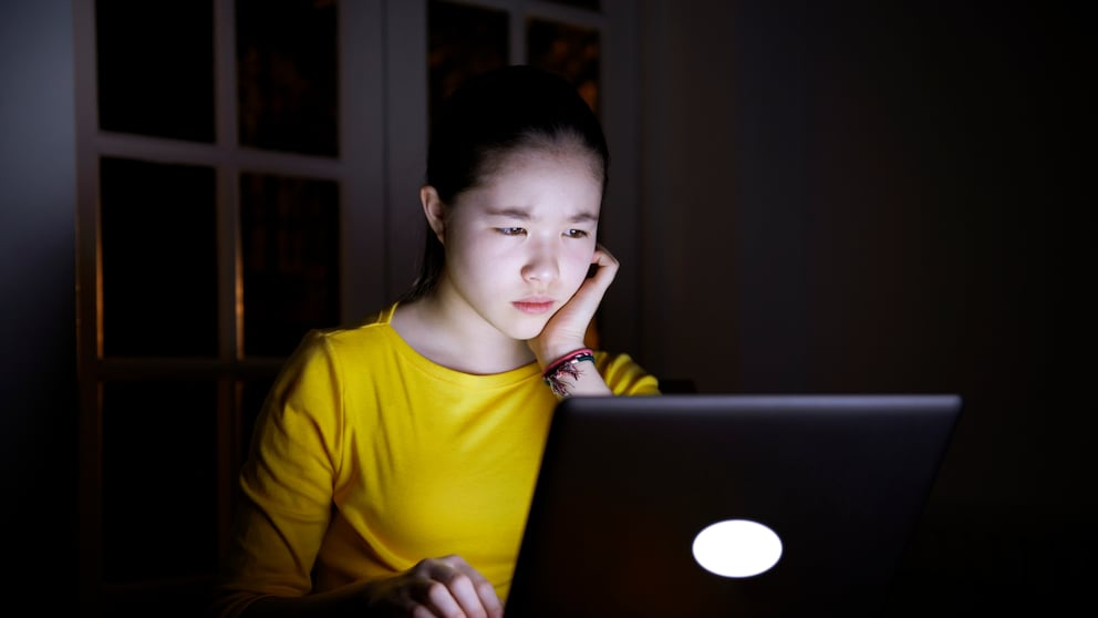 Frau sitzt mit ernstem Gesicht vor einem Laptop