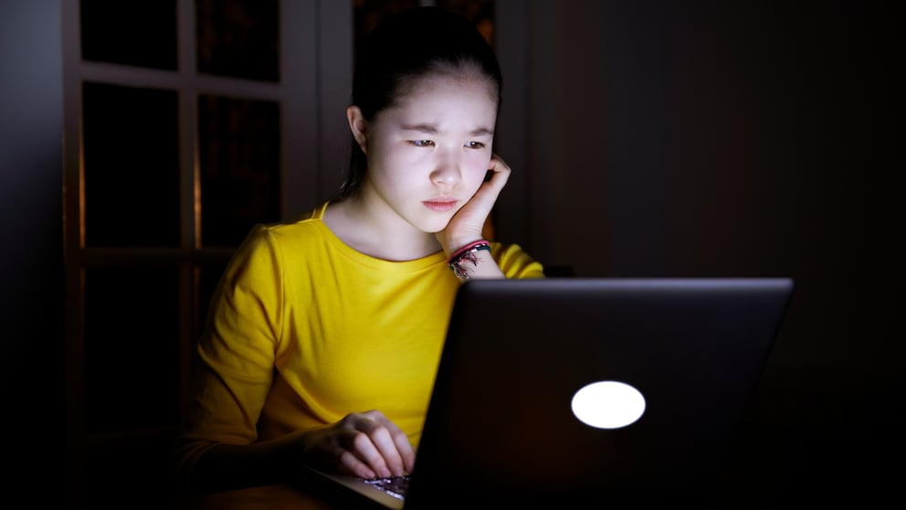 Frau sitzt mit ernstem Gesicht vor einem Laptop