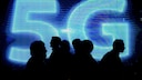 Menschen stehen vor einem 5G-Logo