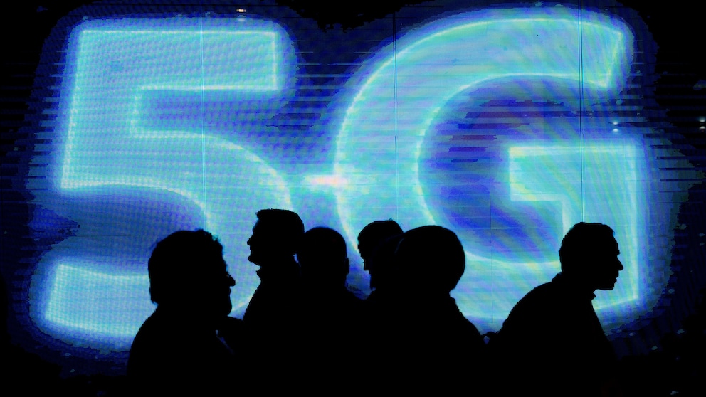 Menschen stehen vor einem 5G-Logo