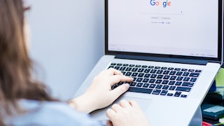 Frau mit Google-Suche auf MacBook