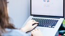 Frau mit Google-Suche auf MacBook