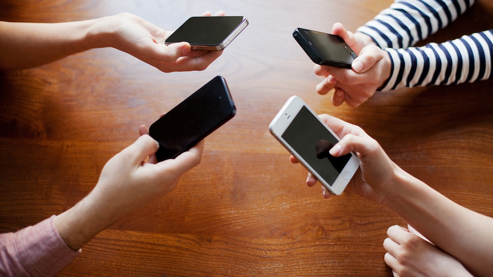 4 friends sharing on smart phones.