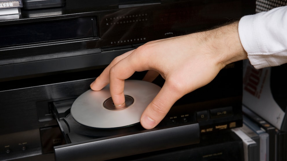 Jemand legt eine Disc in einen Player