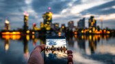 Mann hält Smartphone in der Hand, auf dem Display sieht man die Skyline von Wien