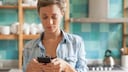 Junge Frau sieht auf Handy
