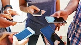 junge Menschen in einem kreis mit ihren Smartphones