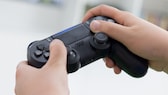 Person hält einen PlayStation-4-Controller