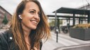 Lächelnde junge Frau trägt Apple AirPods