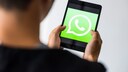 Mann hält iPad mit WhatsApp-App