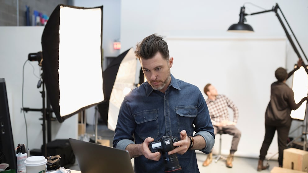 männlicher Fotograf mit Kamera in der Hand