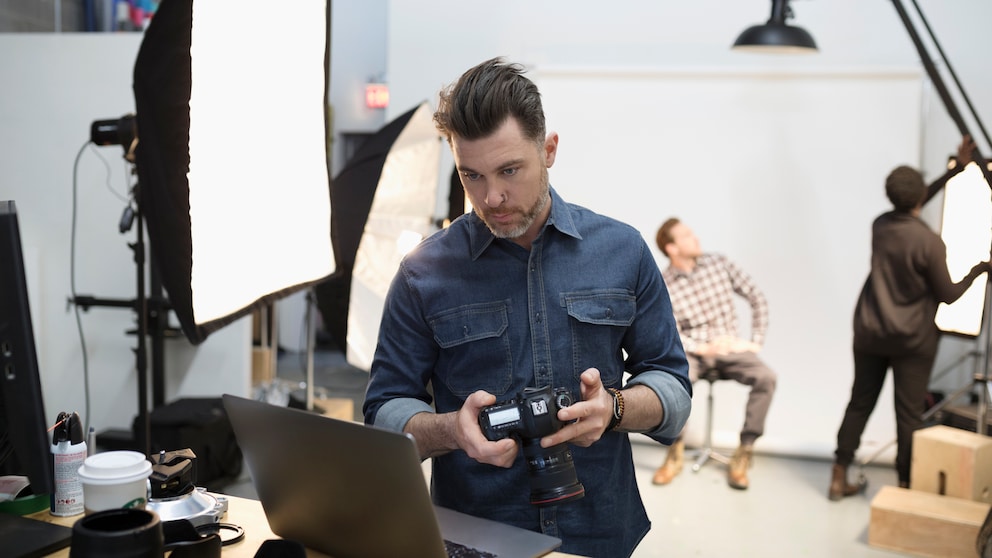 männlicher Fotograf mit Kamera in der Hand