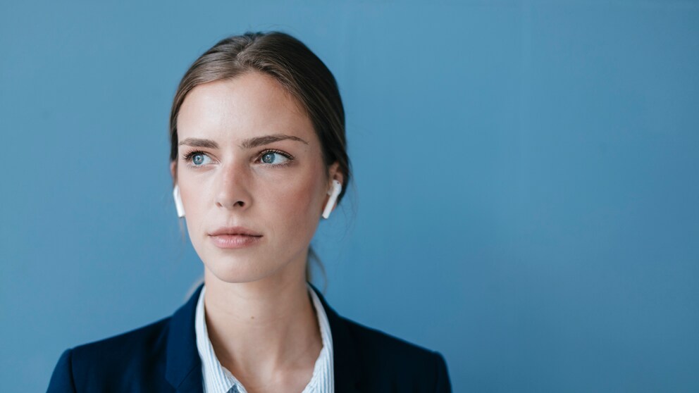 junge Frau hört mit kabellosen In-Ear-Kopfhörern