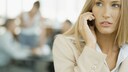 Blonde Frau telefoniert mit Handy