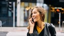 Rothaarige Frau telefoniert mit dem Handy auf der Straße