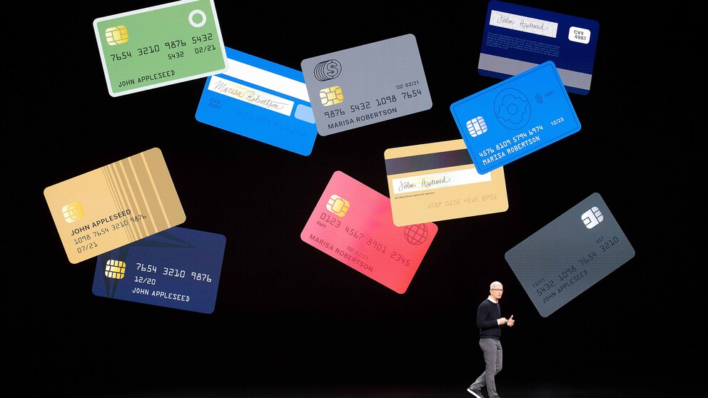 Der CEO von Apple, Tim Cook, steht vor einer Leinwand, auf der viele Apple Cards zu sehen sind