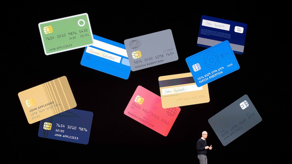 Der CEO von Apple, Tim Cook, steht vor einer Leinwand, auf der viele Apple Cards zu sehen sind