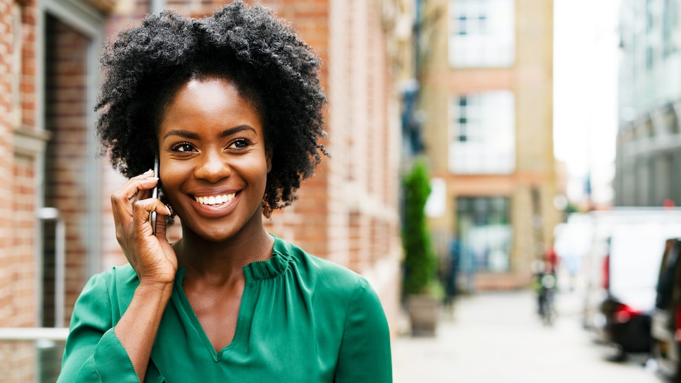 Frau telefoniert unterwegs mit dem Smartphone