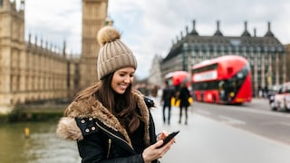 Frau mit Smartphone in London vor dem Big Ben