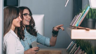 Kundin und Verkäuferin vor dem Smartphone-Regal