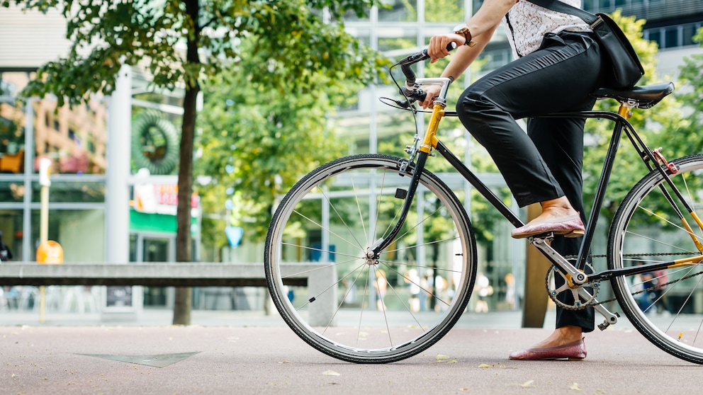 Beine einer Frau, die auf dem Fahrrad sitzt