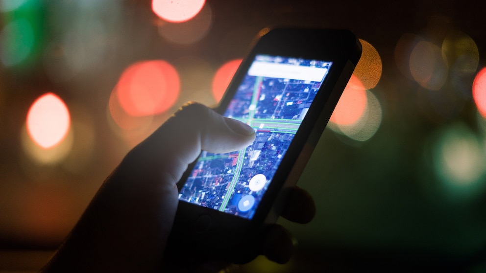 Smartphone mit Netzkarte vor verschwommenem Hintergrund