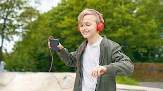 Junge hört über Kopfhörer Musik