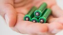 Hand mit vier AAA-Batterien