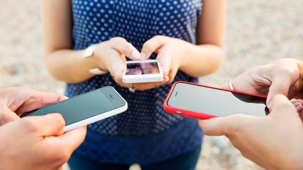 Handytarife-Vergleich: SmartGruppe mit drei Menschen, die ein Smartphone halten