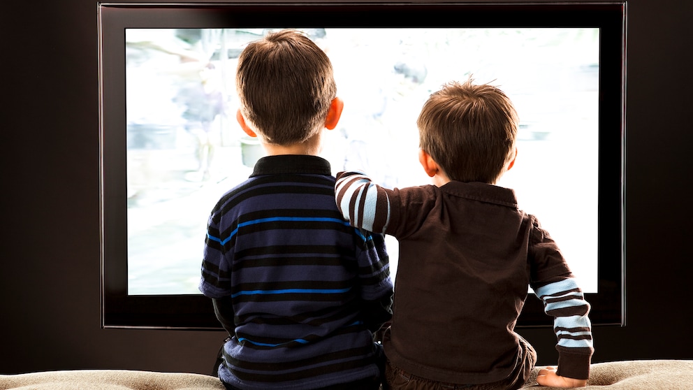 Netflix kindersicher machen mit der Kindersicherung Symbolbild: Zwei kleine Jungen sitzen vor dem Fernseher mit dem Rücken zur Kamerai