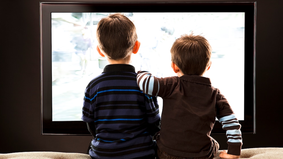 Netflix kindersicher machen mit der Kindersicherung Symbolbild: Zwei kleine Jungen sitzen vor dem Fernseher mit dem Rücken zur Kamerai