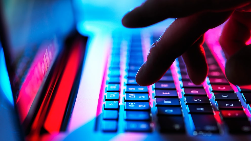 Symbolbild Internetkriminalität Coronavirus: Hand tippt auf einer Computer-Tastatur