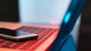 Laptop und Smartphone in rotem Licht