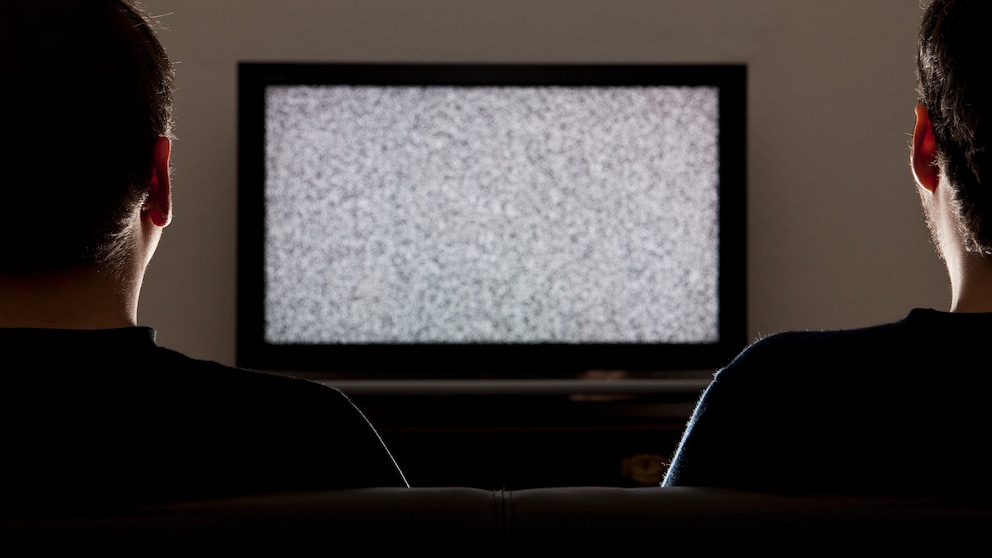 Symbolbild Coronavirus Abschaltung Video-Streaming Schweiz: Zwei Männer schauen auf einen Fernseher ohne Bild