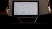 Symbolbild Coronavirus Abschaltung Video-Streaming Schweiz: Zwei Männer schauen auf einen Fernseher ohne Bild
