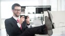 Symbolbild Smartphone Streaming App Quibi: Mann mit Handy im Büro