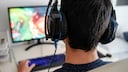 Gaming-Rechner bei Aldi: Symbolbild Junge mit Headset sitzt vor einem Bildschirm