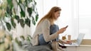 Frau mit Handy und Laptop