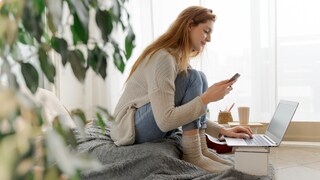 Frau mit Handy und Laptop