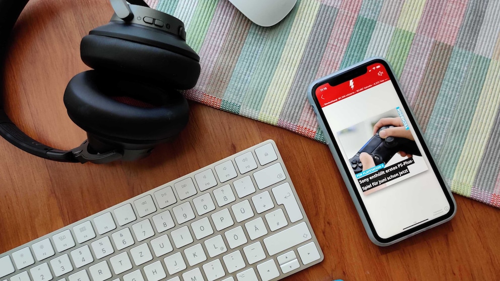 Smartphone mit geöffneter BUZZ-App liegt neben Tastatur