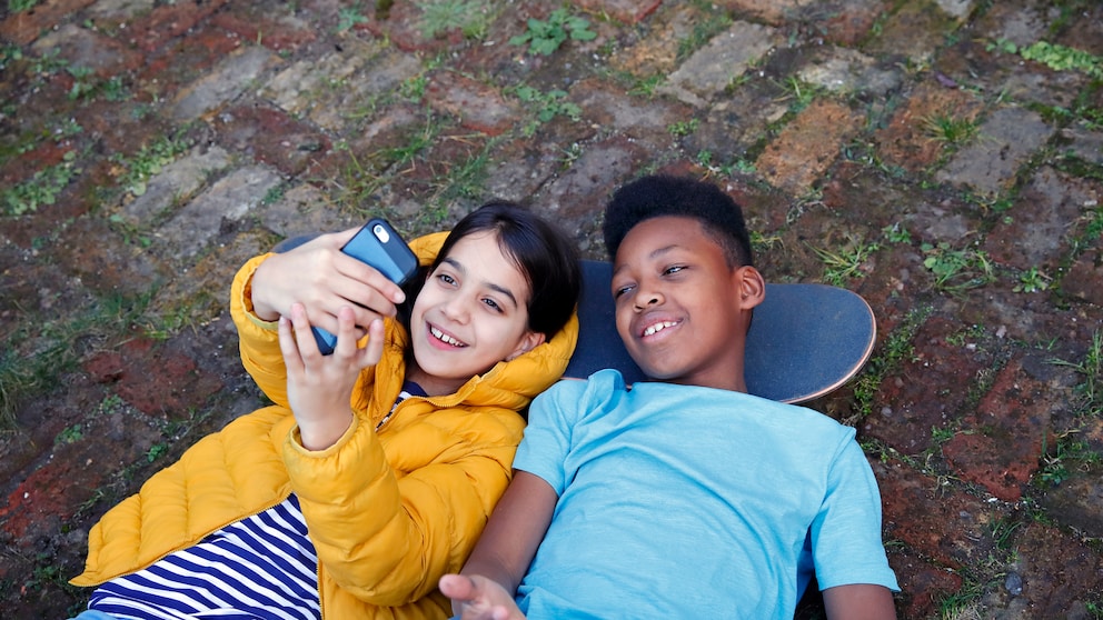 Zwei Kinder mit Handy