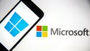 Smartphone mit Windows-Logo vor Microsoft-Logo