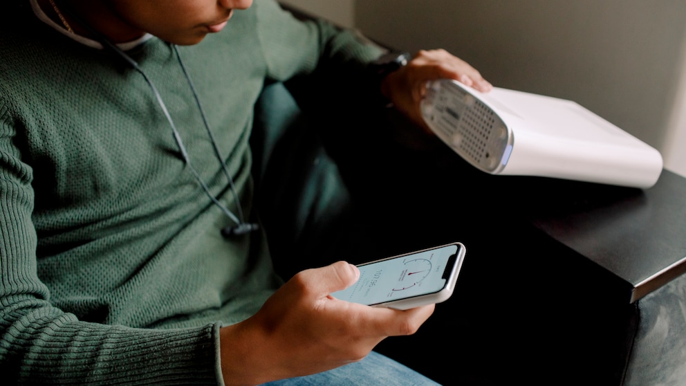 Mann überprüft WLAN-Verbindung an Smartphone und Router
