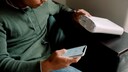 Mann überprüft WLAN-Verbindung an Smartphone und Router